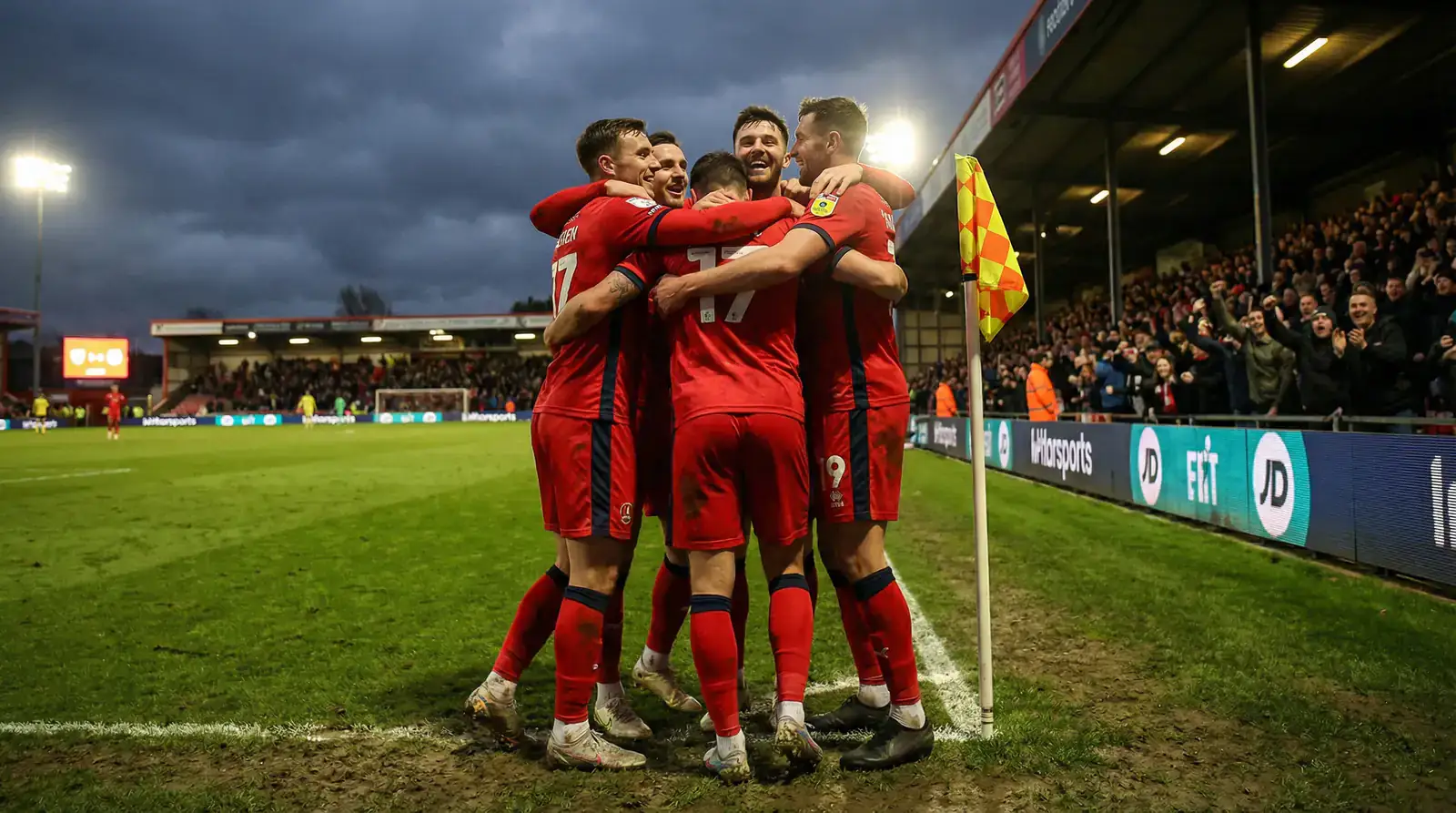 Fußballmannschaft in roten Trikots feiert einen Torerfolg auf dem Spielfeld bei einem Qualifikationsspiel